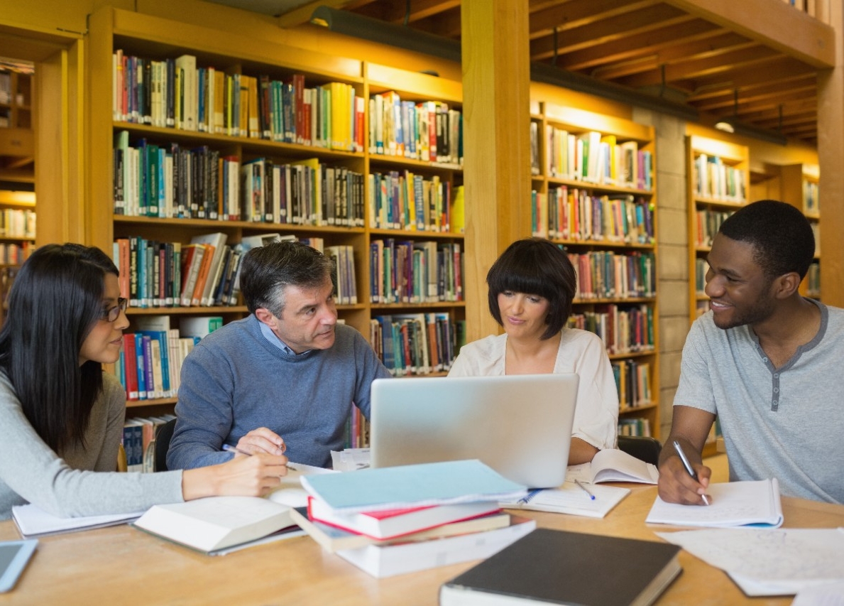 Groep mensen die in een bibliotheek zitten te werken