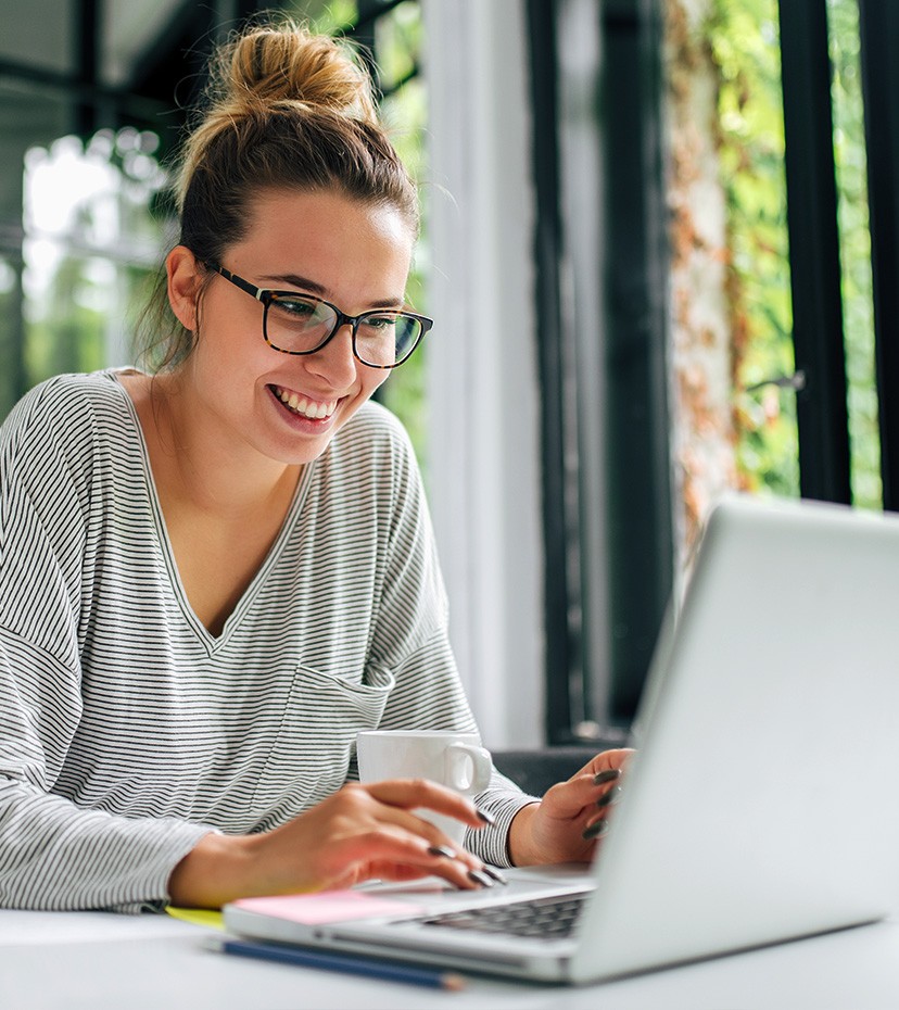 Photo: Woman on laptop in library