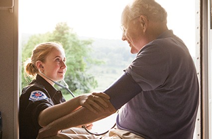 Female medical technician attends elderly man