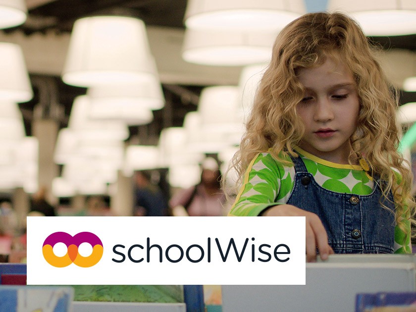 Foto: Schoolmeisje bladert door titels in een bibliotheek