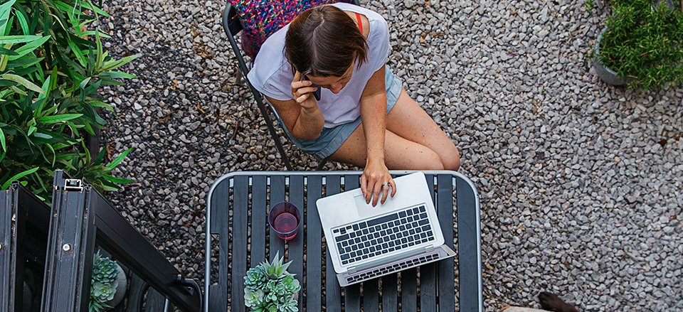 A library patron on their phone and using a laptop