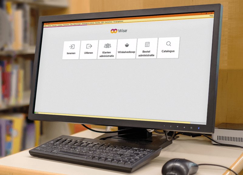 Een computerscherm waarop het startmenu van het Wise-bibliotheeksysteem zichtbaar is, met opties zoals 'Innemen', 'Uitlenen', 'Klantenadministratie', 'Winkelverkoop', 'Besteladministratie' en 'Catalogus'. Op de achtergrond zijn boekenplanken in een bibliotheek te zien.